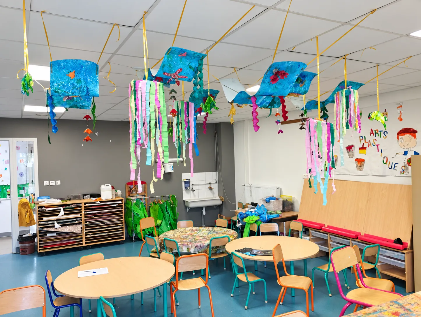 Créations sur le thème de l'océan suspendues au plafond d'une salle de classe après un atelier