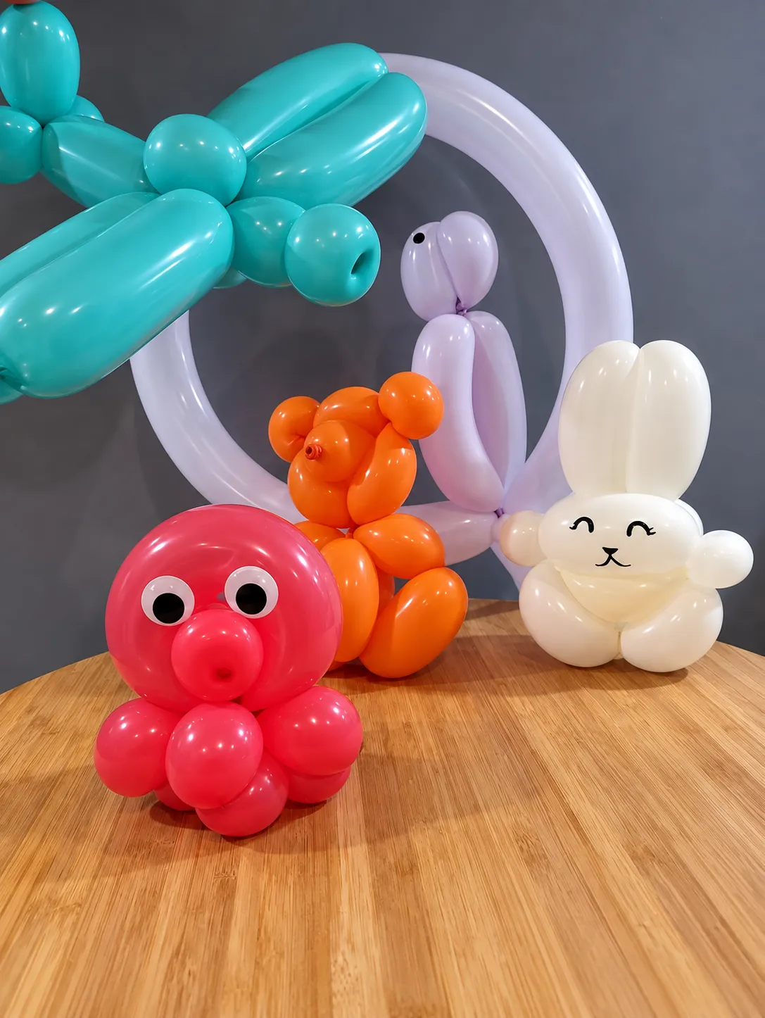 Pieuvre, ourson, lapin et chien sculptés en ballons, posés sur une table