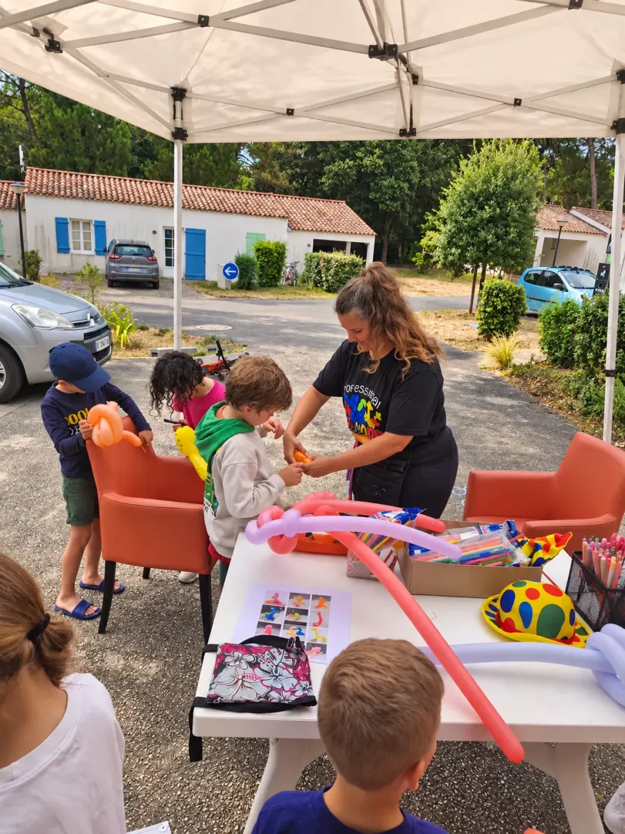 Stand fixe de sculpture sur ballons sous tonnelle, enfants autour de la table