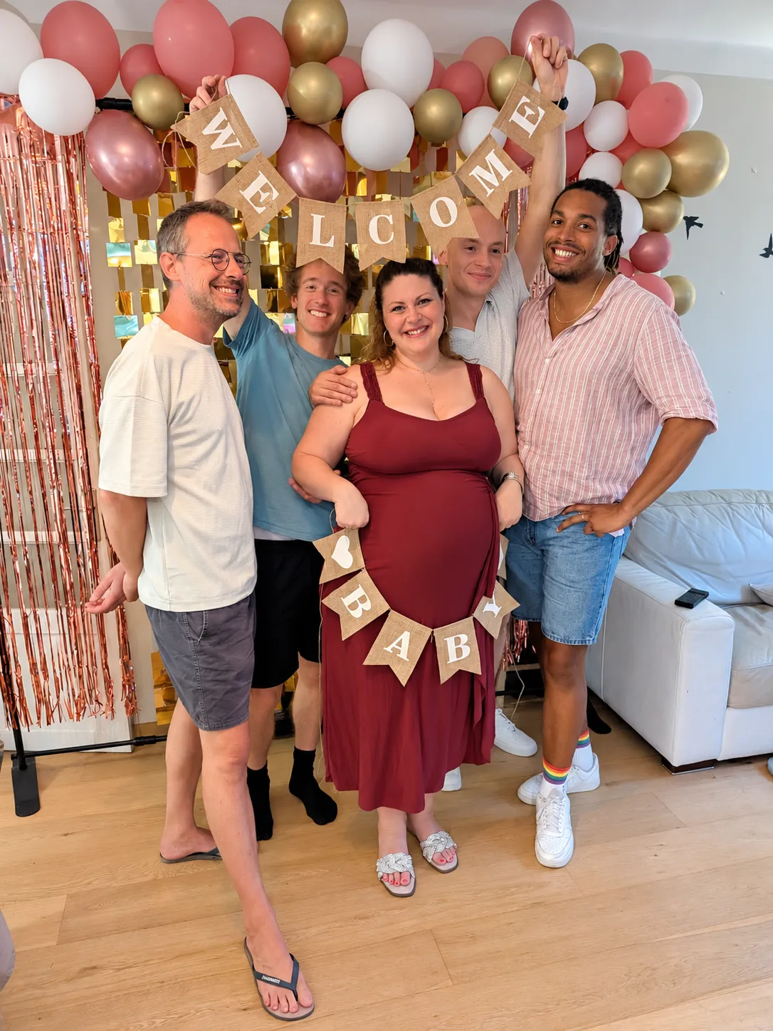 Famille réunie devant le décor de ballons d'une baby shower