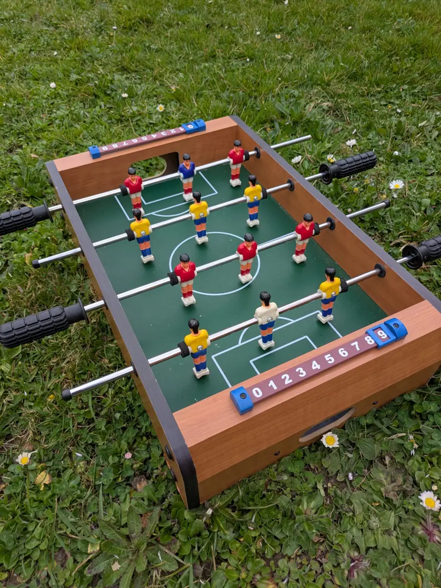Baby-foot en bois installé sur la pelouse pour l'espace enfants