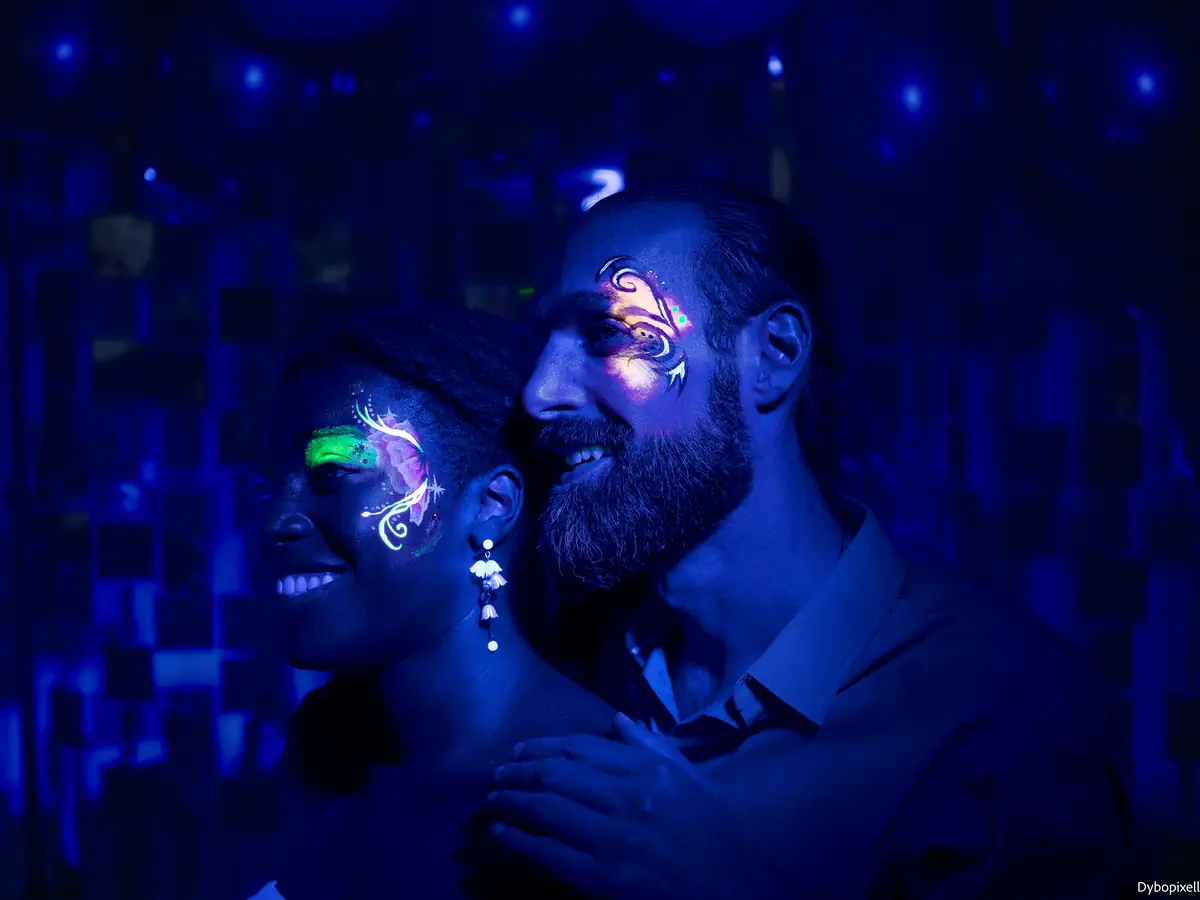 Maquillage fluorescent sous lumière noire lors d'une soirée