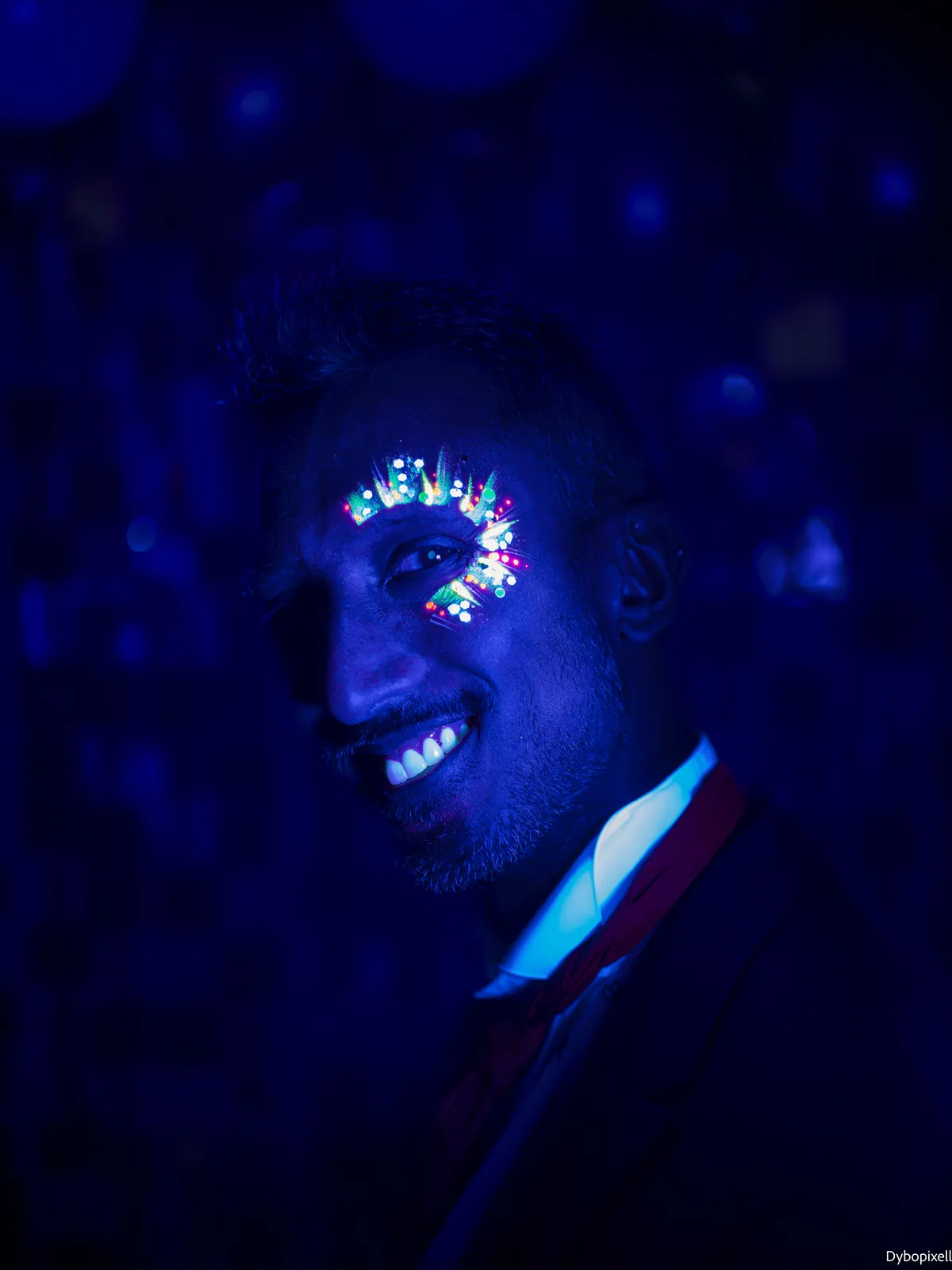 Invité souriant, maquillage fluo lumineux sous lumière noire