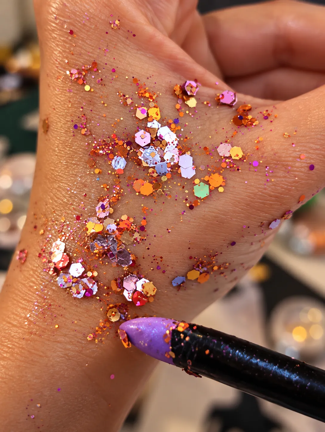 Motif de paillettes posé sur le dos d'une main au bar à paillettes